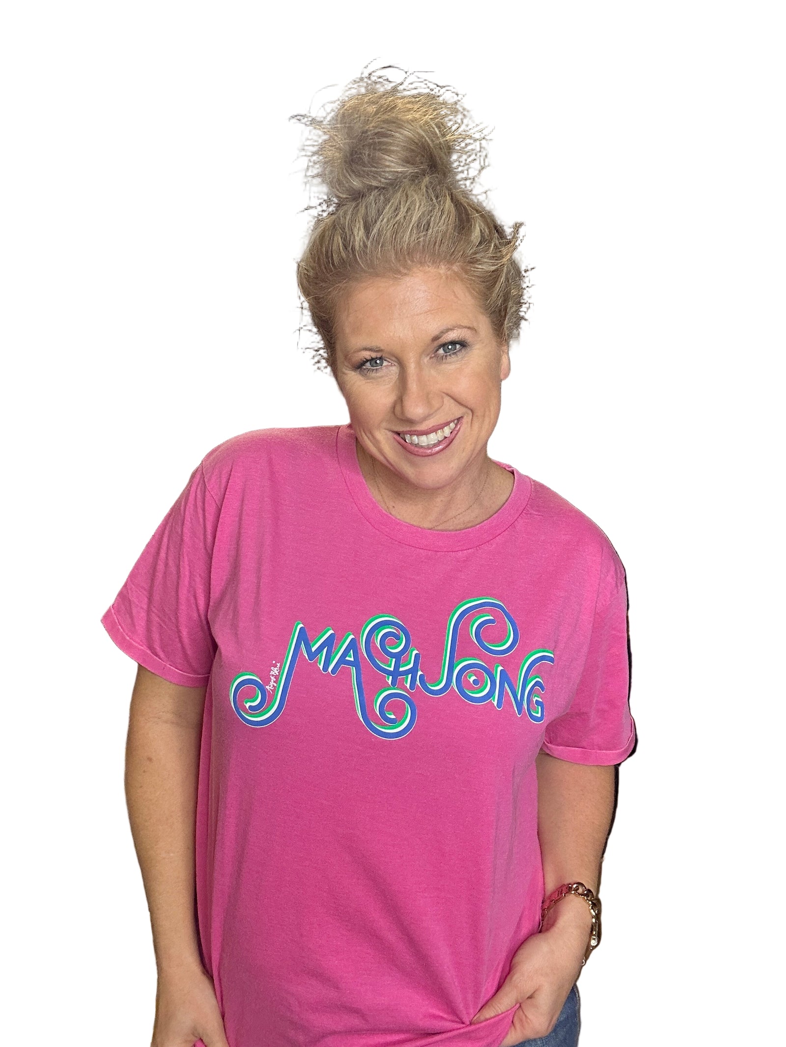 Person wearing a pink t-shirt with colorful text in an indoor setting