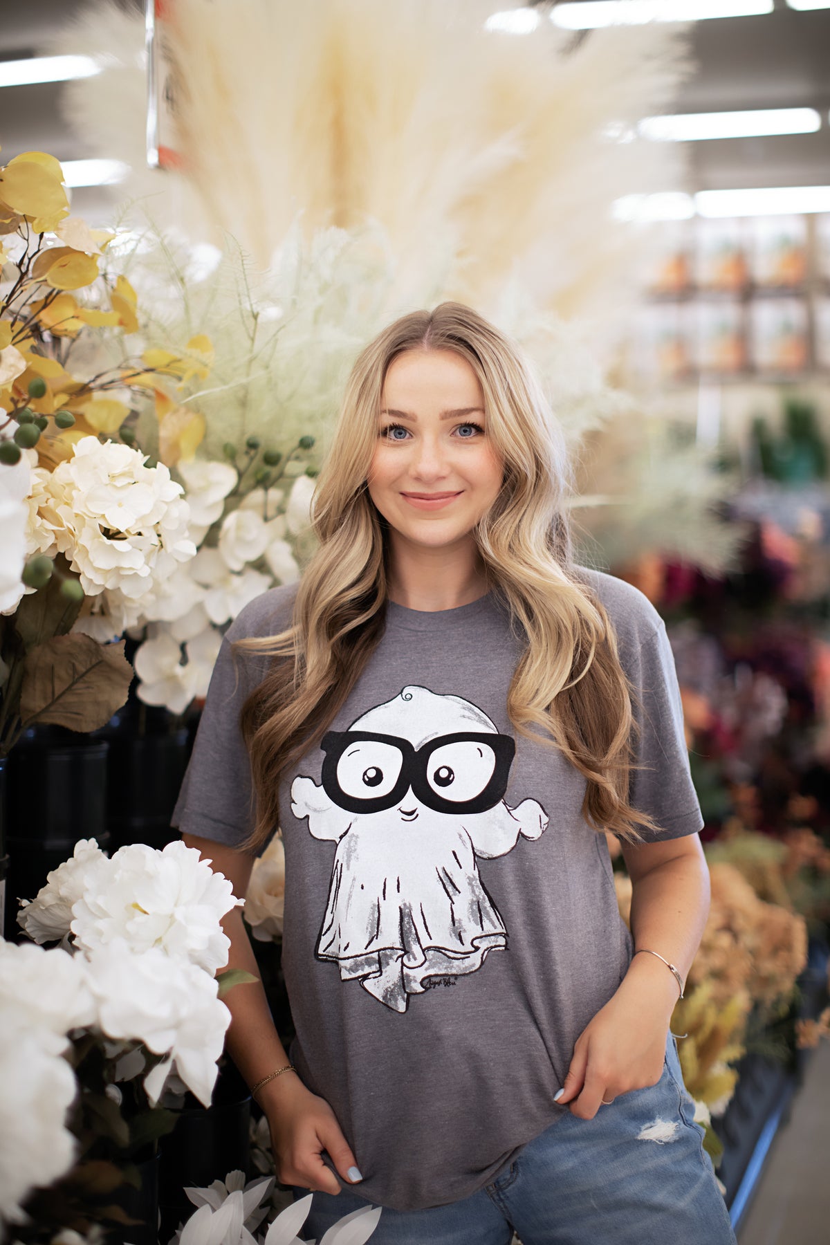 a cute ghost with large glasses on a grey crew neck tee
