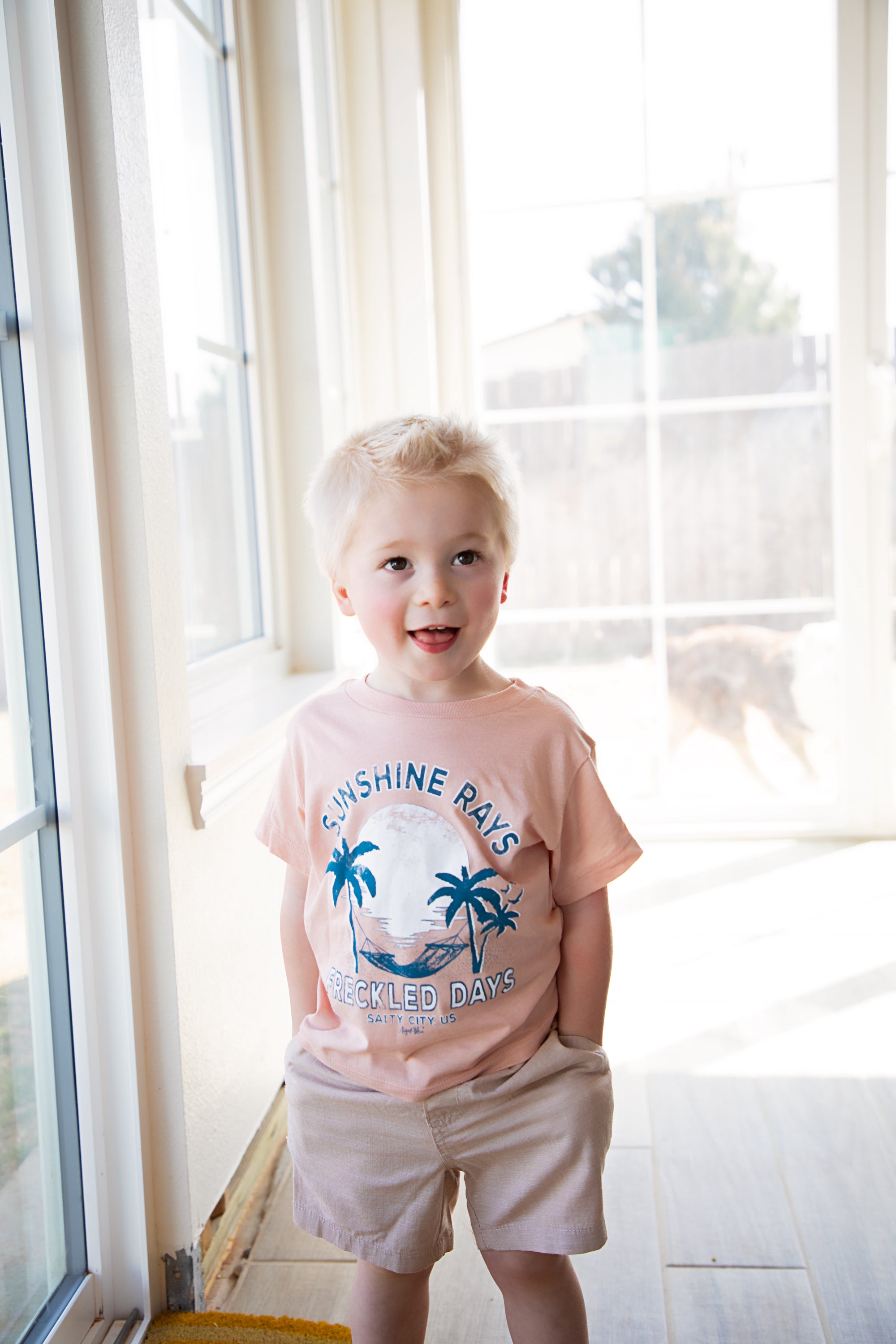 Sunshine Rays and Freckled days palm tree with hammock and setting sun graphic- peach kids short sleeve crew neck tee